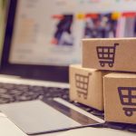 Shopping online concept - Shopping service on The online web. with payment by credit card and offers home delivery. parcel or Paper cartons with a shopping cart logo on a laptop keyboard
